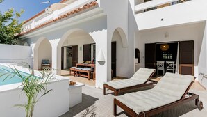 A modern villa with a pool, lounge chairs, and a dining area. - Sea La Vie Quintessential Algarve Villa with Pool in Manta Rota (Vila Nova de Cacela)