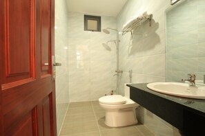 A bathroom with a toilet, a sink, and a shower.