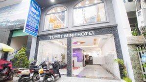 The exterior of Tuyet Minh Hotel with a clear entrance, a signboard, and parked scooters. - Tuyet Minh Hotel (Ho Chi Minh City)