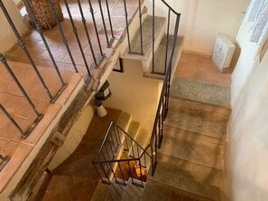 A staircase with a metal railing, stone steps, and a basket on the landing. - Panorama Toscano with Splendid Sea Views, Terrace and Whirlpool (Metato)