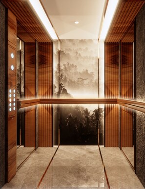 A modern elevator with wooden paneling and a central mural of a landscape.