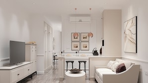 Una cocina moderna con comedor, televisor y sofá.