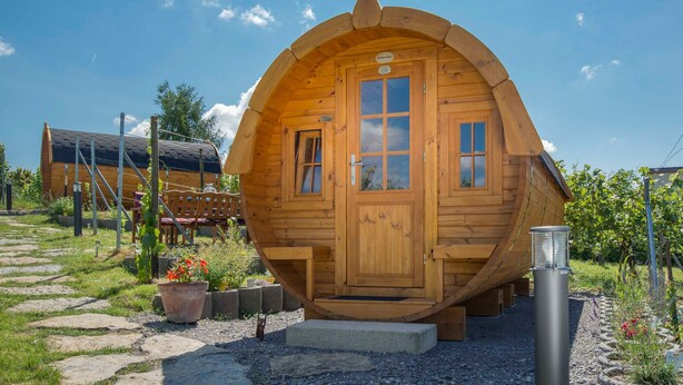 Eine Holzhütte mit gewölbtem Dach, einer Haustür und einer kleinen Veranda.