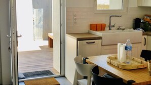 Une cuisine équipée d’un évier, d’un plan de travail et d’un coin repas avec une table et des chaises.