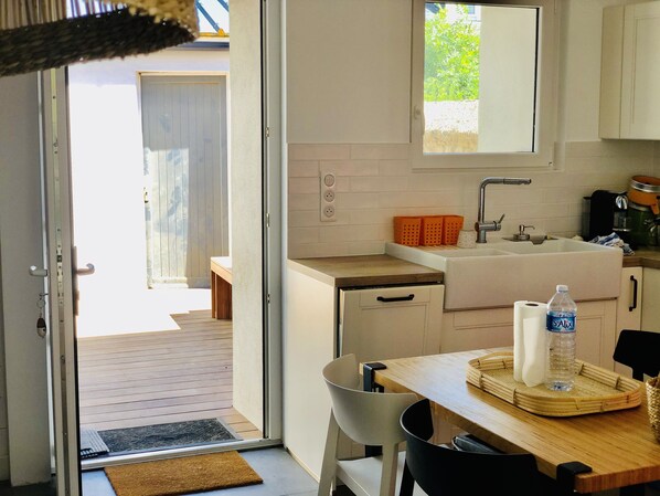 A kitchen with a sink, countertop, and a dining area with a table and chairs.
