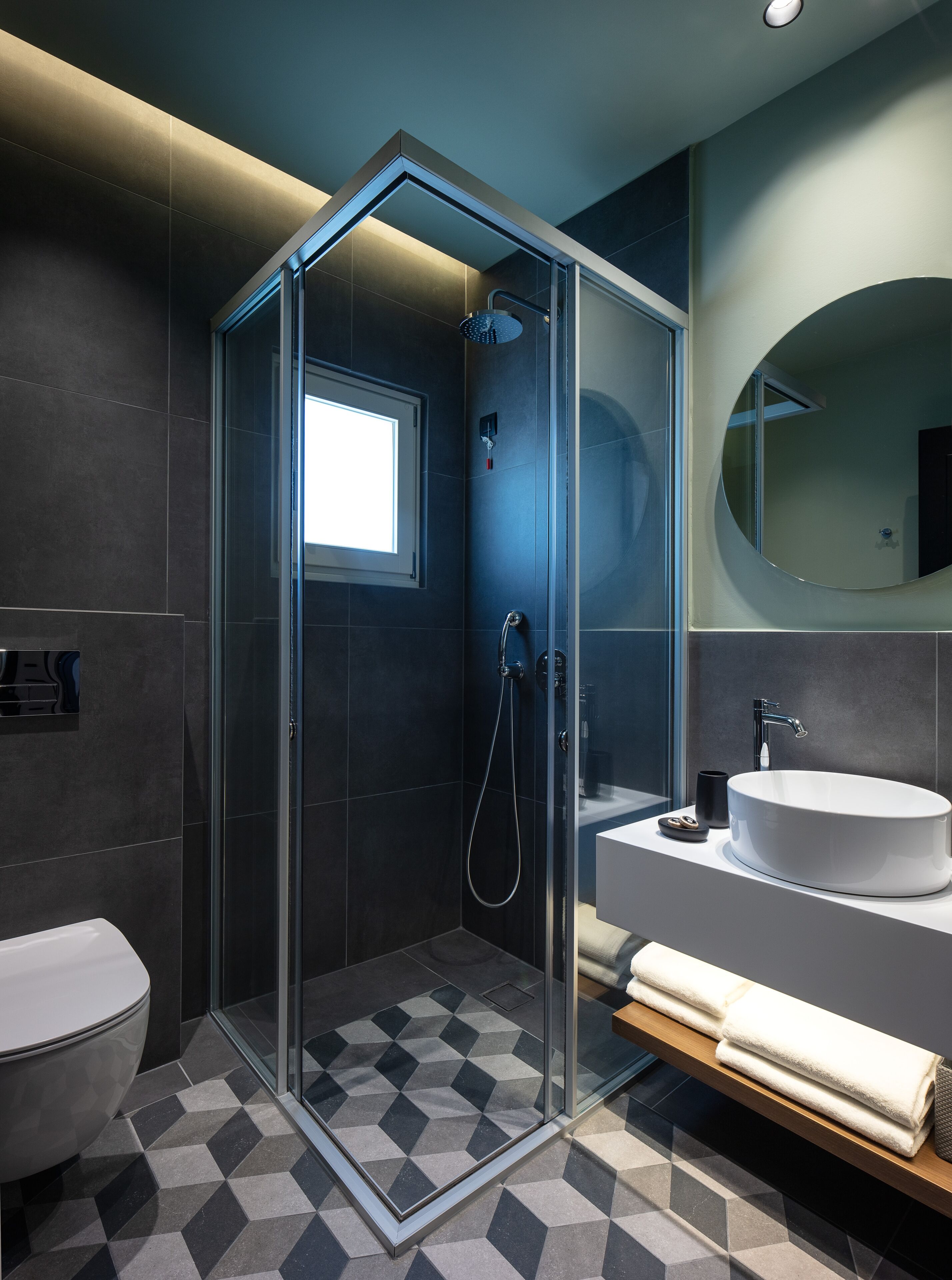 Une salle de bain moderne avec une douche à parois de verre, un lavabo blanc et des toilettes.