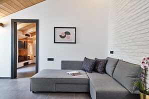 Deluxe Suite, 1 Bedroom (The room is located on the loft level and is accessible via stairs) | Living area | 43-inch Smart TV with satellite channels, TV, MP3 dock -  Λιθεία-Lithia (Ioannina)