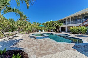 A swimming pool with a sunken area, surrounded by a patio with a hammock and lounge chairs. - Sand Dollar Dream - Remodeled Canal Private Pool Home - By Island Real Estate Va (Anna Maria)