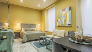 Een moderne hotelkamer met een bed, nachtkastjes, een bureau en een slaapbank.