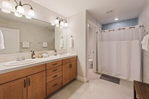 Enjoy a refreshing shower in the bathroom with a double sink and spacious mirror.