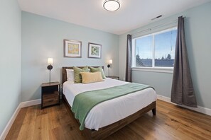 Relax in this serene bedroom with a large bed, two bedside tables, and a window with curtains.
