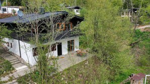 A two-story house with a satellite dish, a small porch, and a stone staircase. - Vacation home Frankenglück - Apartment Holz vor der Hütt'n (Egloffstein)