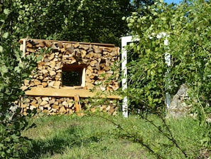 Eine rustikale Holzhütte mit Steinwand, kleinem Fenster und Holztür.