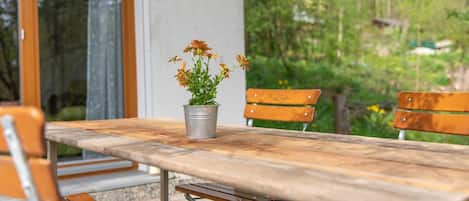 A wooden table with a metal frame, a potted plant, and wooden chairs.