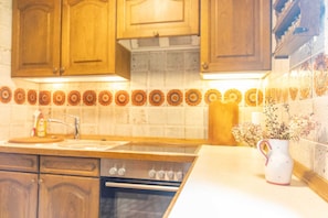A kitchen with wooden cabinets, a stove, an oven, and a decorative tile backsplash.