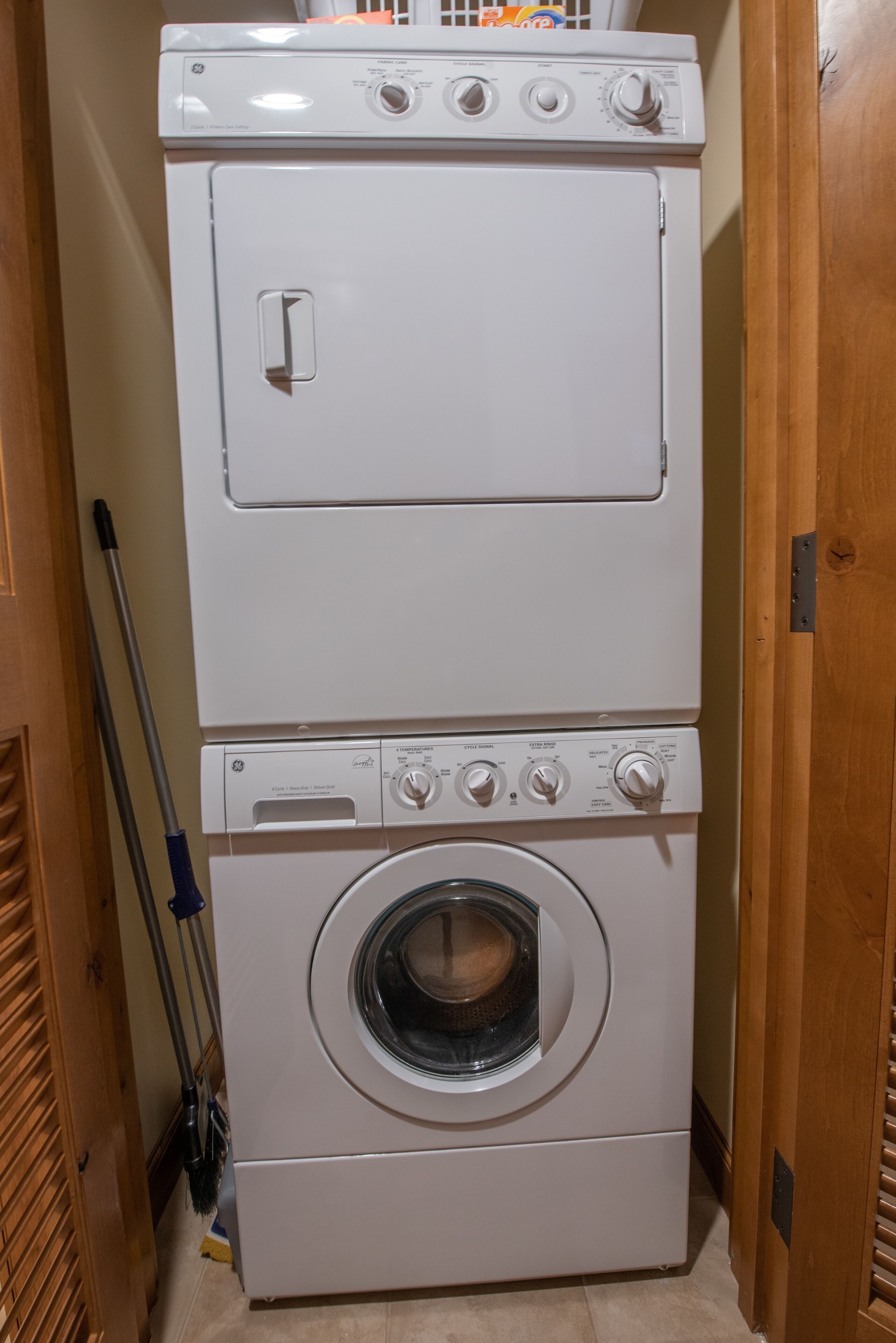 A stacked washer and dryer unit in a hallway.