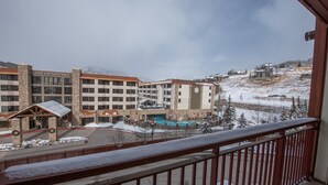 Et hotel med en stenfasadé, flere etager og et poolområde.