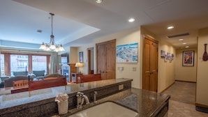 A kitchen with granite countertops, a sink, and a chandelier.