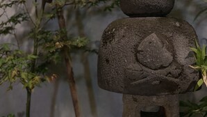 A stone lantern with a leaf design, set against a backdrop of bamboo plants. - Asakusa Kaminarimon Takenoyado (Tokyo)