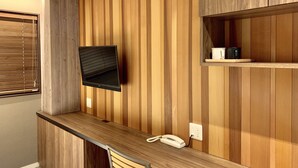 A modern kitchen with wooden paneling, a built-in TV, a countertop, and a phone. - Asakusa Kaminarimon Takenoyado (Tokyo)