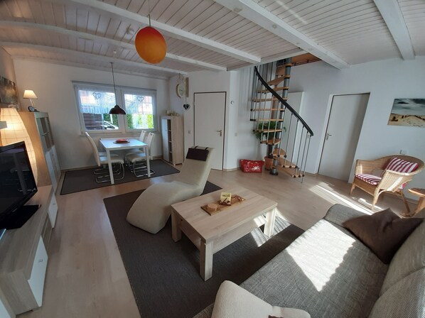 A modern living room with a sofa, coffee table, and a staircase with a spiral design.