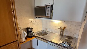 A compact kitchenette with a microwave, coffee maker, sink, and a small refrigerator. - Studio for 3, slopeside in Les Adrets (Les Adrets-Prapoutel)