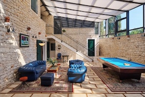 Relax in a spacious area with a sofa, chair, and pool table.