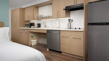 A modern kitchen with wooden cabinets, a stainless steel refrigerator, a microwave, and a dishwasher.
