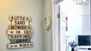 A hallway with a wall-mounted sign and a clock. - Modern Flat on The Hoe w/ Private Parking (Plymouth)