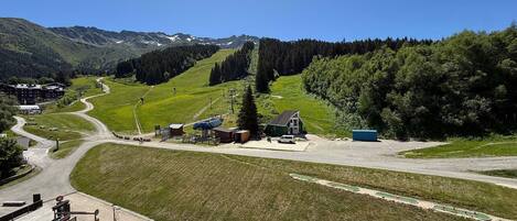 A mountain resort with a ski lift, a small lodge, and a parking area.