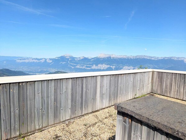 Una terraza de madera con vistas a montañas distantes.