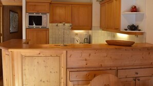 A kitchen with wooden cabinets, a microwave, a coffee maker, and a decorative candelabra.