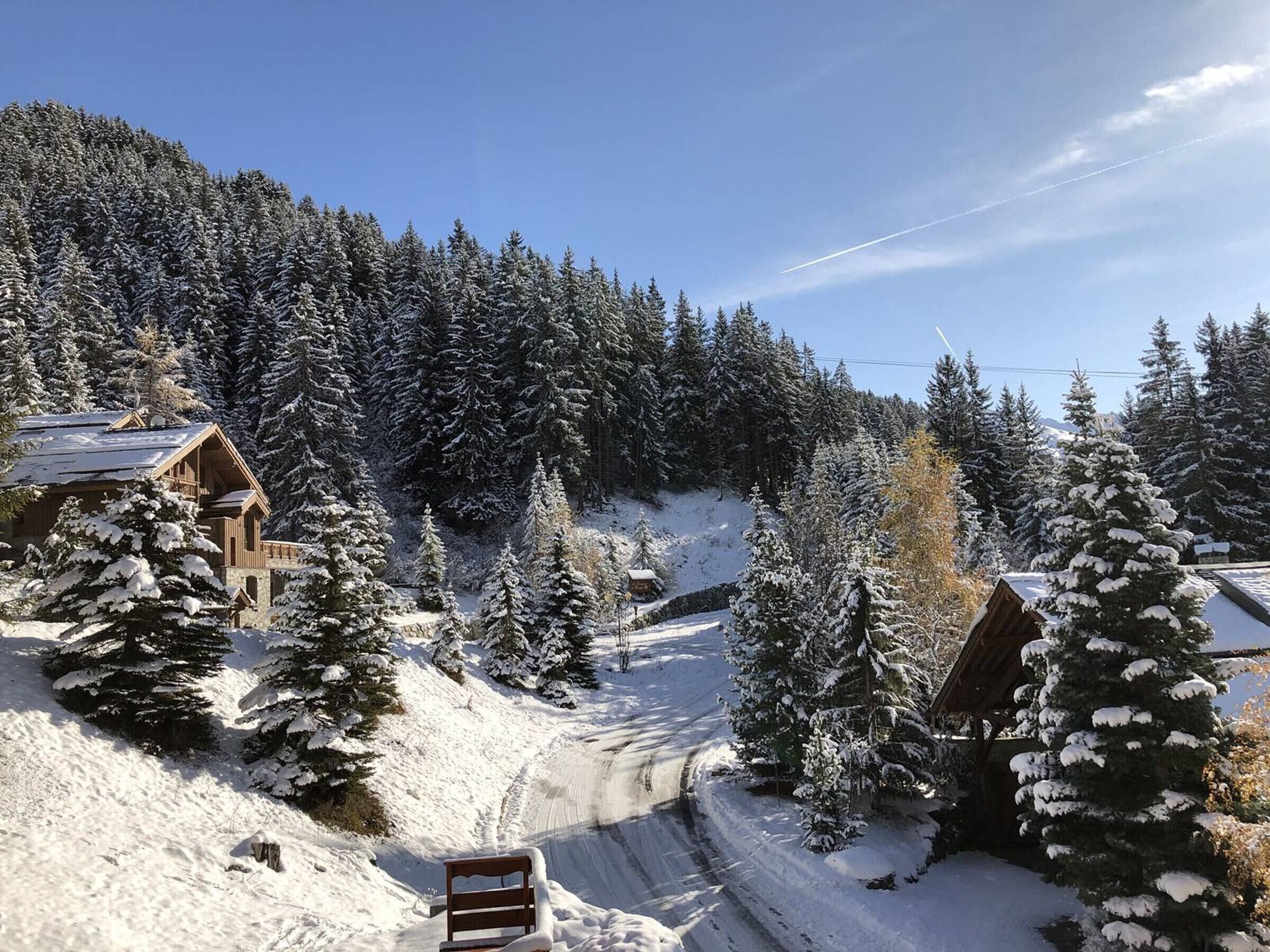 A snow-covered mountain area with wooden cabins and a clear sky.