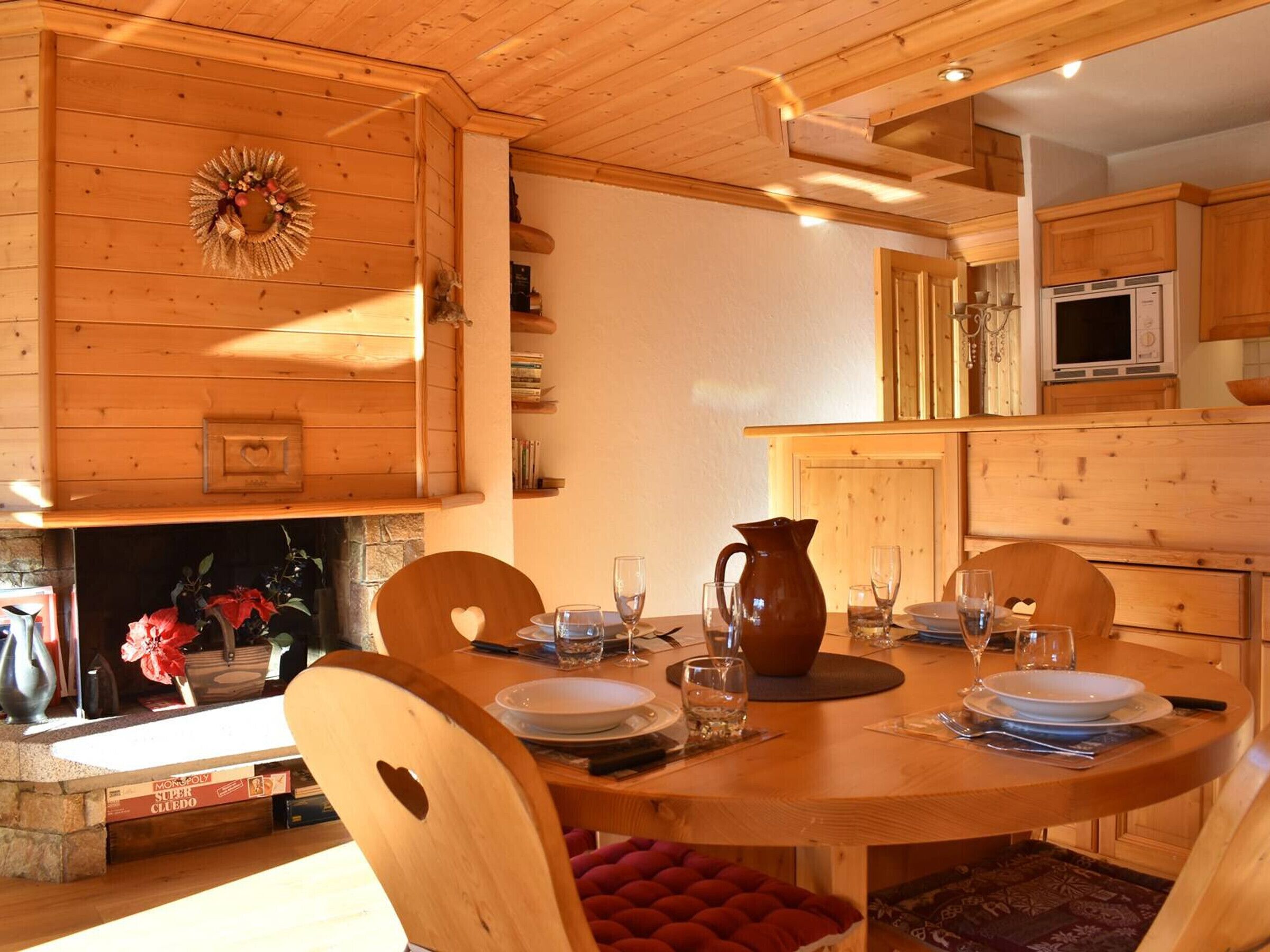 Un comedor de madera con chimenea, televisor y estantería.