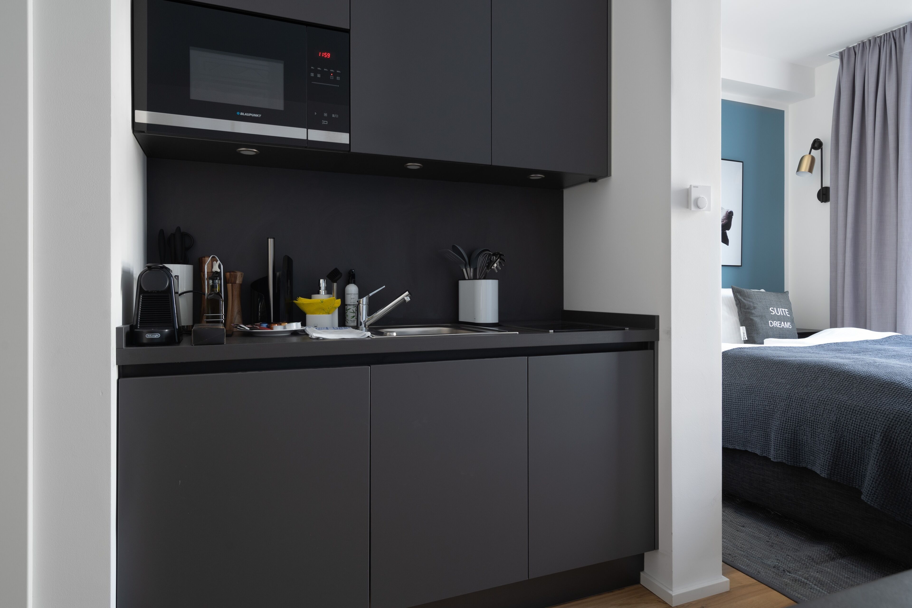 Una cocina moderna con microondas, cafetera y utensilios.
