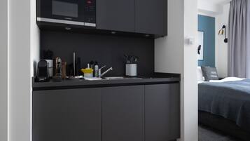Una cocina moderna con microondas, cafetera y utensilios.