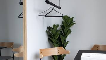 Una habitación moderna con un espejo de marco de madera, una planta en maceta y una mesa con superficie negra.