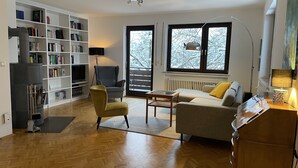Una sala de estar con sofá, sillón y estantería.
