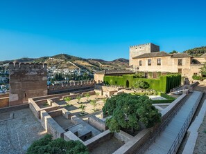 Une forteresse ancienne, dotée d’une tour, d’une cour avec des allées et d’un bâtiment surmonté d’un toit en tuiles.