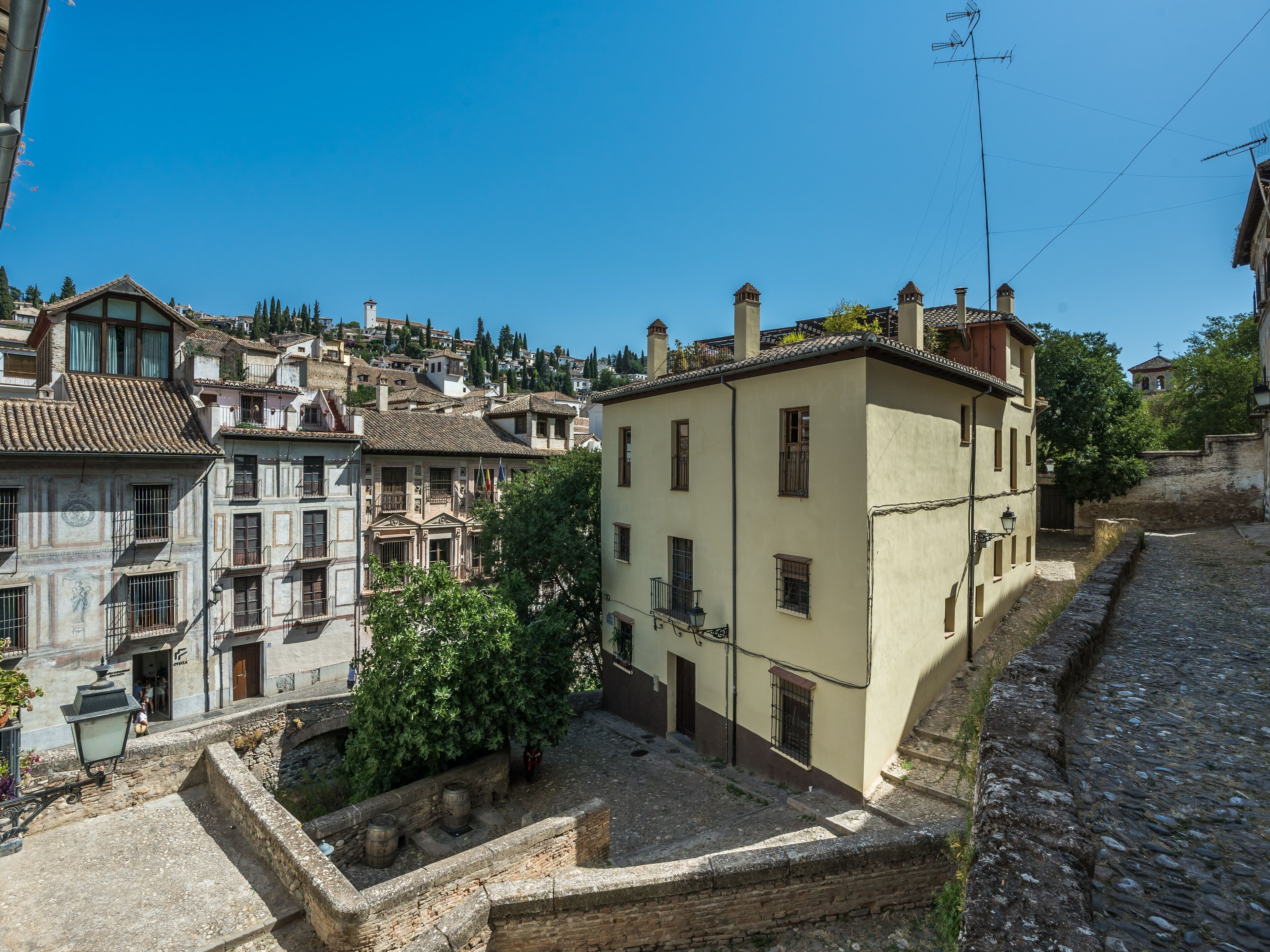 Un pueblo histórico con arquitectura tradicional, calles empedradas y un edificio destacado con balcón.