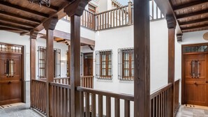 Ein mehrstöckiges Gebäude mit hölzernen Balkonen, gefliestem Boden und einer Holztür.