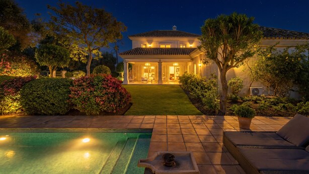A well-lit residential property at night with a swimming pool, outdoor seating, and a manicured garden. - ELEGANT VILLA FOR GOLFERS: OUTDOOR BBQ, POOL AND SOLARIUM, PLUS HOME CINEMA ROOM (San Pedro de Alcántara)