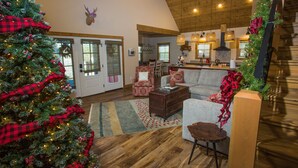A cozy living room with a large Christmas tree, a fireplace, and a dining area. - Bluff Cabin #4 Lake Retreat, Lake Views & a Relaxing Hot Tub, NO pet cabin (Kimberling City)