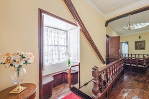 A staircase with wooden railings and a red carpet leading to a landing.