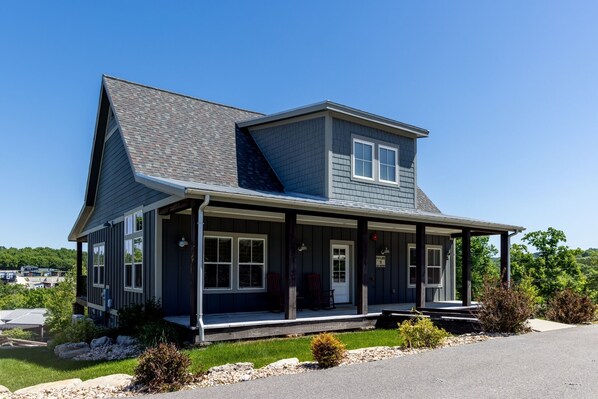Ein zweistöckiges Haus mit Veranda, Garage und Auffahrt.