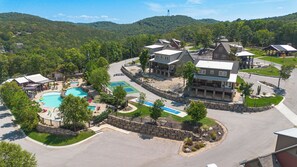 A resort with a swimming pool, tennis courts, and a large building with a porch. - Poolside Cabin #13 Luxury 3 bedroom - Perfect Family Retreat for 8 people. (Kimberling City)