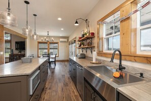 A modern kitchen with a central island, stainless steel appliances, and wooden cabinetry.