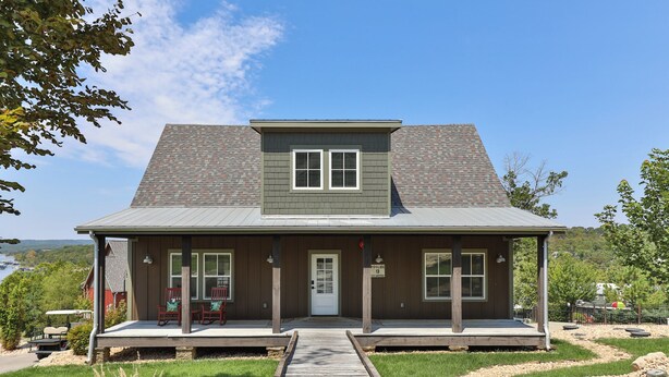 A two-story house with a porch, a front door, and a sign indicating a poolside location. - Poolside Cabin #13 Luxury 3 bedroom - Perfect Family Retreat for 8 people. (Kimberling City)