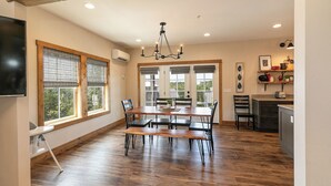 A spacious kitchen with a dining area, wooden flooring, and a chandelier. - Poolside Cabin #13 Luxury 3 bedroom - Perfect Family Retreat for 8 people. (Kimberling City)