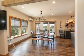 A spacious kitchen with a dining area, wooden flooring, and a chandelier. - Poolside Cabin #13 Luxury 3 bedroom - Perfect Family Retreat for 8 people. (Kimberling City)